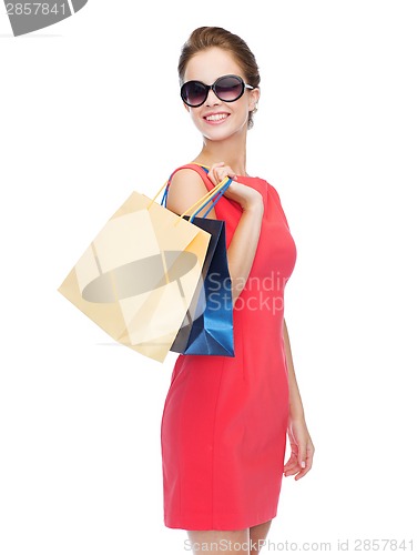 Image of smiling woman in red dress with shopping bags