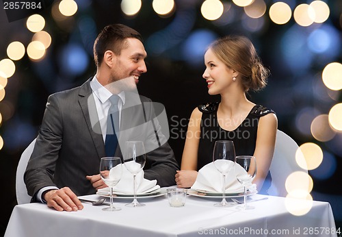 Image of smiling couple looking at each other at restaurant