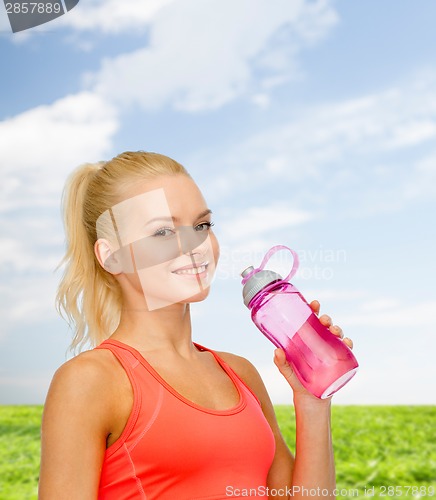 Image of smiling sporty woman with water bottle