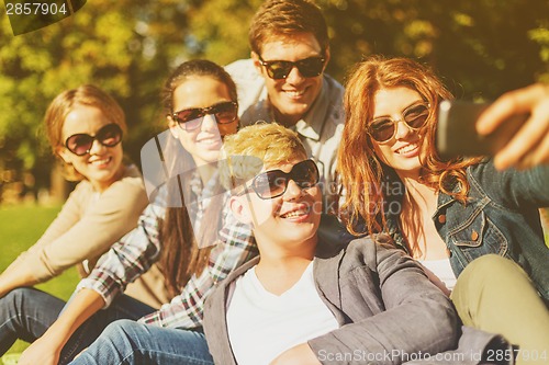 Image of teenagers taking photo with smartphone outside