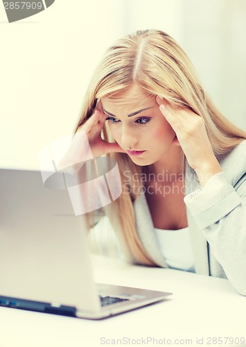 Image of stressed woman with laptop