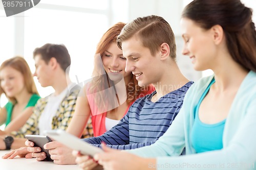 Image of smiling students with tablet pc at school