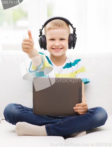 Image of little boy with tablet pc and headphones at home