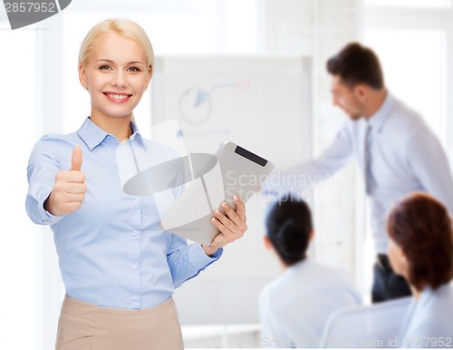 Image of smiling woman looking at tablet pc computer