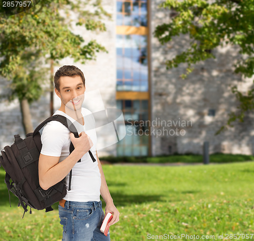 Image of travelling student with backpack and book