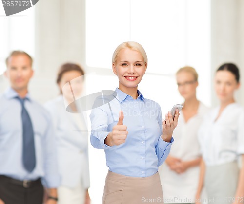 Image of young smiling businesswoman with smartphone