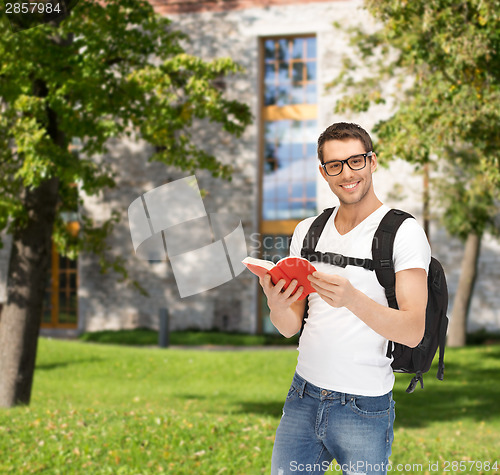 Image of travelling student with backpack and book