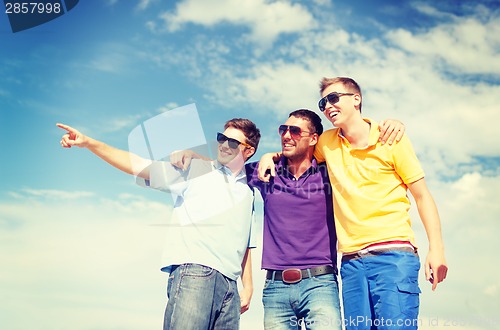 Image of group of male friends walking on the beach