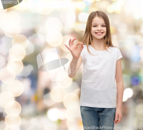 Image of little girl in white t-shirt showing ok gesture