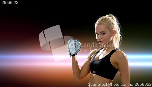 Image of young sporty woman with heavy steel dumbbell