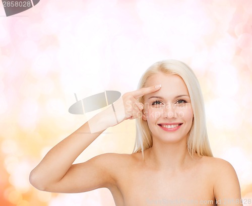 Image of beautiful woman touching her forehead