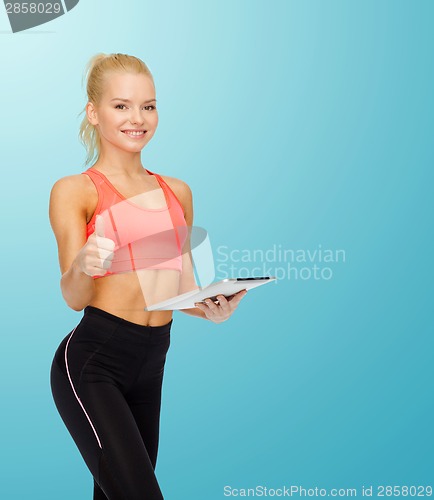 Image of smiling sporty woman with tablet pc computer