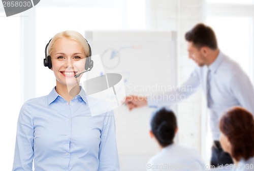 Image of friendly female helpline operator with headphones