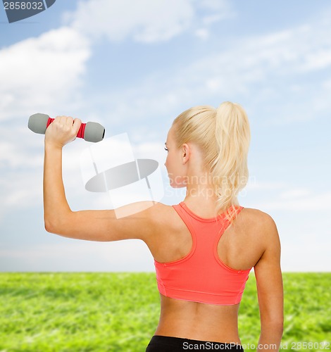 Image of young sporty woman with light dumbbell