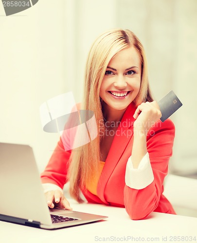 Image of businesswoman with laptop using credit card