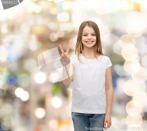 Image of little girl in white t-shirt showing peace gesture