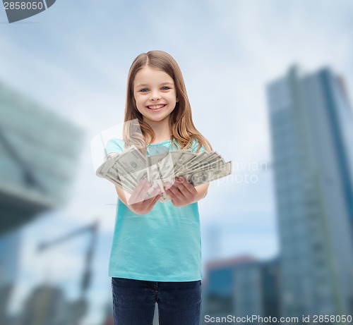 Image of smiling little girl giving dollar cash money