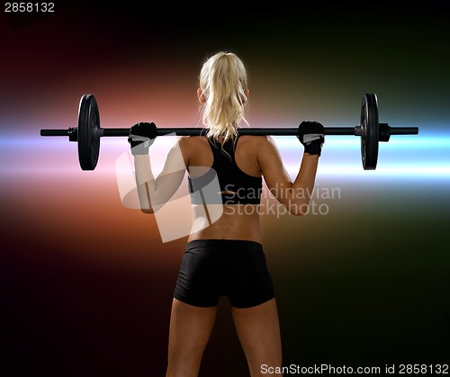 Image of sporty woman exercising with barbell from back