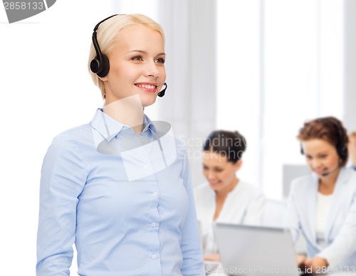 Image of friendly female helpline operator with headphones