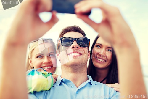Image of friends taking picture with smartphone camera