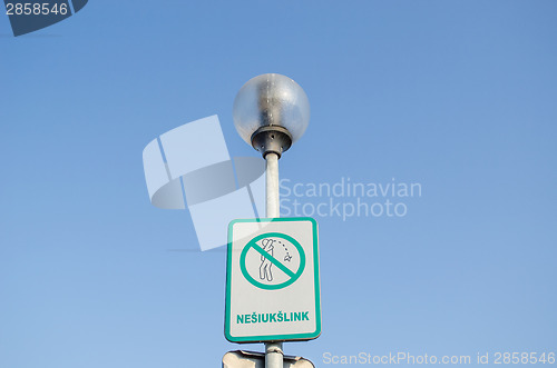 Image of warning sign on littering streets on street lamp 