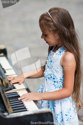 Image of Little girl playing on a piano