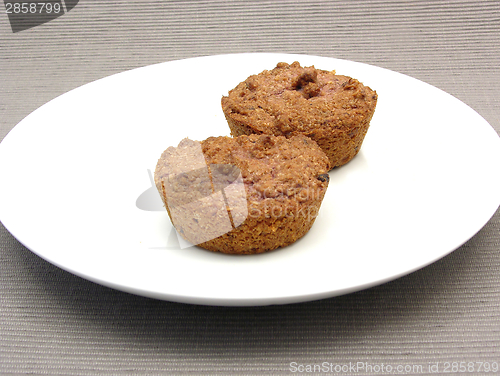 Image of Two raspberry muffins on a white plate of chinaware