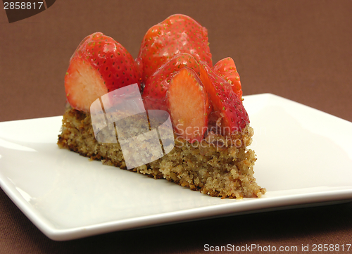 Image of One slice of strawberry cake on white plate an brown background