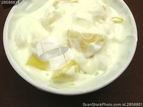 Image of Pieces of pineapple in yogurt and and a white bowl of chinaware