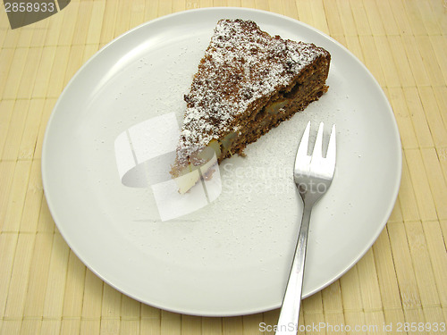 Image of One slice of pear cake on a white plate dusted with powder sugar