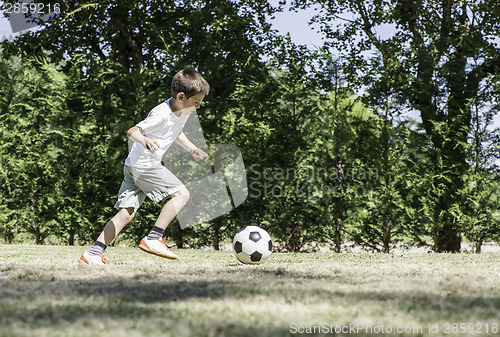 Image of Child playing football in a stadium