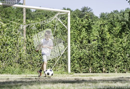 Image of Child playing football in a stadium