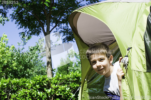 Image of Child peeks from a tent