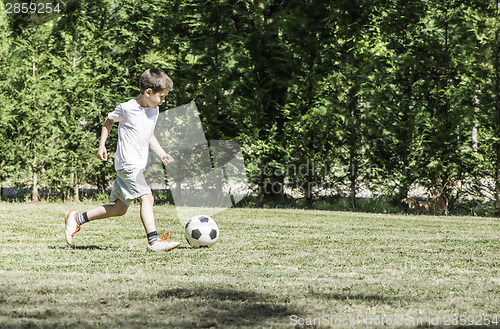 Image of Child playing football in a stadium