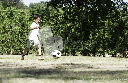 Image of Child playing football in a stadium