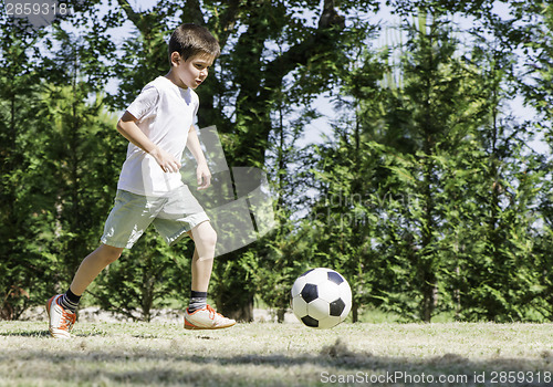 Image of Child playing football in a stadium