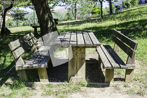 Image of Wooden benches and a table in the woods