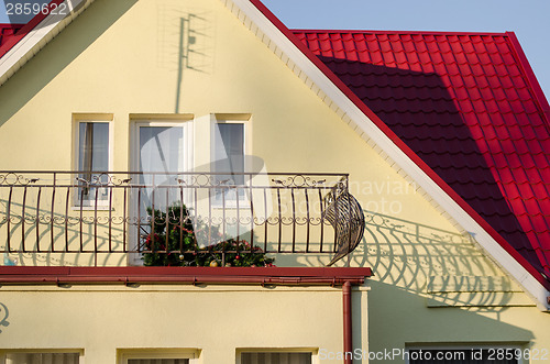 Image of country house and fallen Christmas tree on balcony 