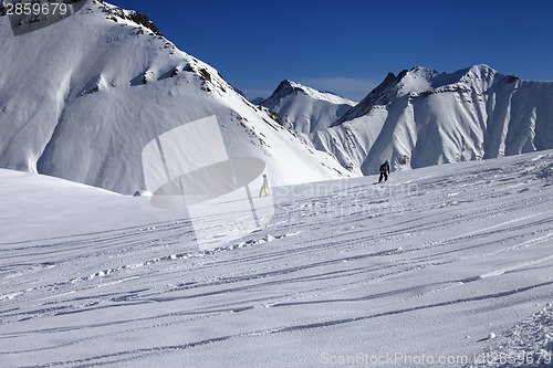 Image of Snowboarders downhill on off piste slope with newly-fallen snow