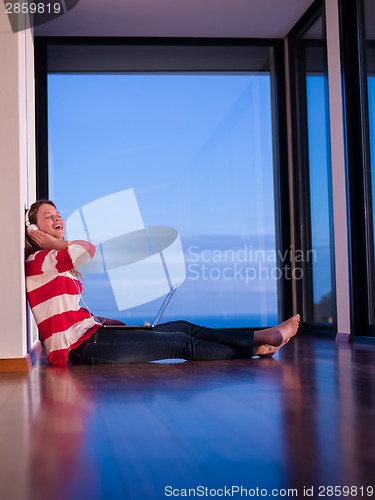 Image of relaxed young woman at home working on laptop