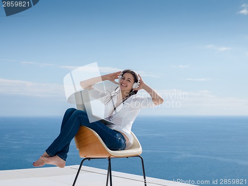 Image of relaxed young woman at home working on laptop