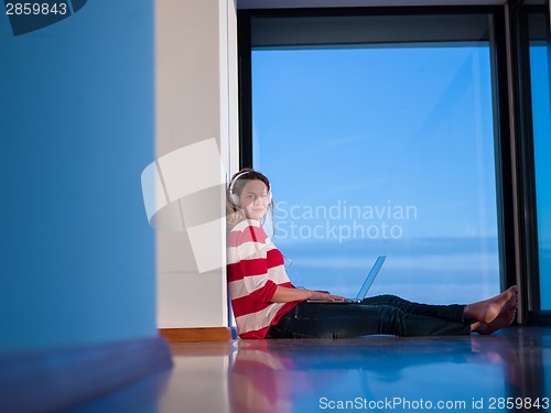 Image of relaxed young woman at home working on laptop