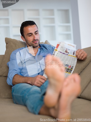 Image of young man relaxing and dreaming on sofa at home