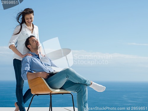 Image of relaxed young couple working on laptop computer at home