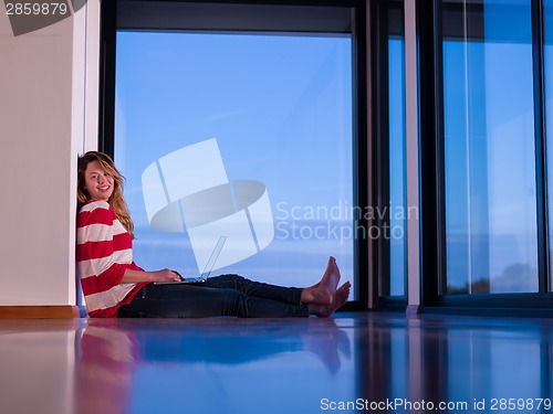 Image of relaxed young woman at home working on laptop