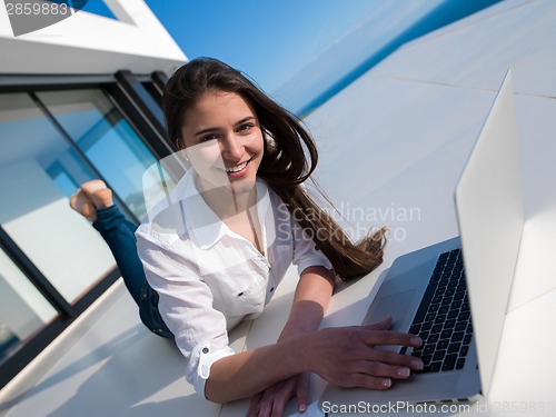 Image of relaxed young woman at home working on laptop