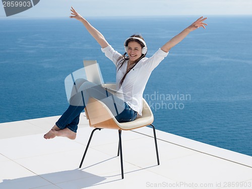 Image of relaxed young woman at home working on laptop