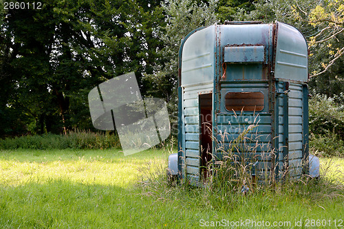 Image of Weathered horsebox standing in a meadow 