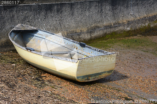 Image of Weather-beaten dinghy on a concrete slipway