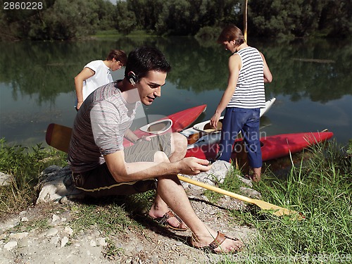 Image of Young men with friends near river